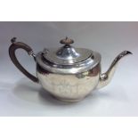 A heavy Edwardian silver teapot decorated with flo