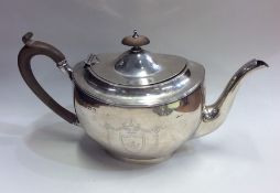 A heavy Edwardian silver teapot decorated with flo