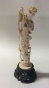 A carved ivory figure of a dancing lady playing a