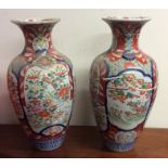 A pair of tall Imari vases decorated with bright c