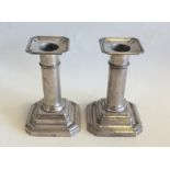 A pair of Edwardian silver candlesticks with cut c