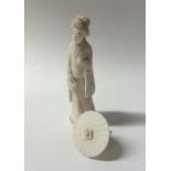 A carved ivory figure of a lady with parasol. Appr