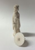 A carved ivory figure of a lady with parasol. Appr