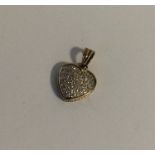 A 9 carat diamond heart shaped pendant with loop t