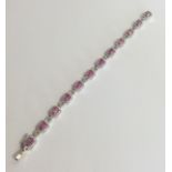 A gold pink sapphire and diamond line bracelet wit