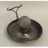An Edwardian silver ashtray mounted with a golf ba