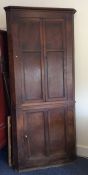 A tall Georgian oak corner cupboard with panelled