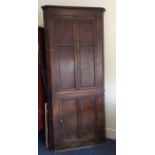 A tall Georgian oak corner cupboard with panelled