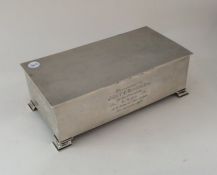 A large silver engine turned cigarette box on brac