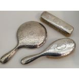 A silver three piece dressing table set of texture
