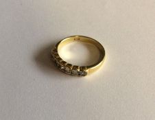 An 18 carat diamond seven stone ring in rubover mo
