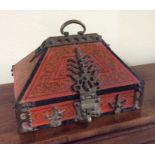 A Chinese red lacquered casket of sloping form. Es
