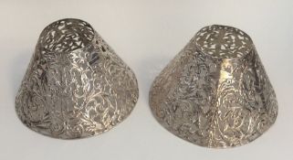 A pair of unusual silver lampshades decorated with