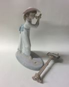 A Lladro figure of a child singing with a bird. Es