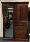 A mahogany combination wardrobe with four drawers.