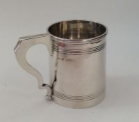 An Edwardian silver tapering mug with reeded body.