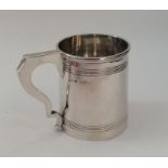 An Edwardian silver tapering mug with reeded body.