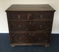 An Antique oak chest of four drawers on bun feet.