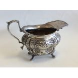 A heavy Edwardian silver cream jug embossed with f