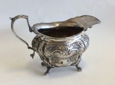 A heavy Edwardian silver cream jug embossed with f