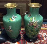 A large pair of brass and cloisonné vases on woode