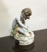 An Antique pottery figure of a child in seated pos