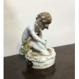 An Antique pottery figure of a child in seated pos