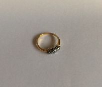 A small diamond three stone ring in two colour gol
