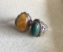 A large amber and silver ring together with one ot