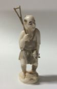 A carved ivory figure of a fisherman in standing p