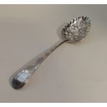 A Georgian silver berry spoon decorated with flowe