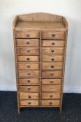 A miniature pine twenty drawer chest with shaped t