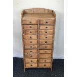 A miniature pine twenty drawer chest with shaped t