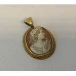 An oval gold framed cameo in relief with loop top.