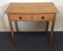 A pine two drawer side table on tapering supports.