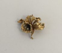A 9 carat brooch in the form of a flower inset wit