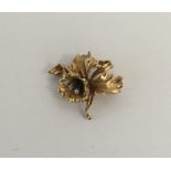 A 9 carat brooch in the form of a flower inset wit