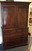 A mahogany five drawer linen press with turned han