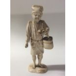 A carved ivory figure of a man with basket. Approx