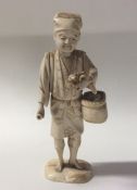 A carved ivory figure of a man with basket. Approx