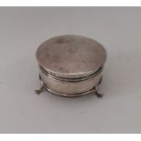 A silver jewellery box on three sweeping supports.