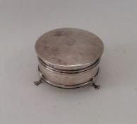 A silver jewellery box on three sweeping supports.