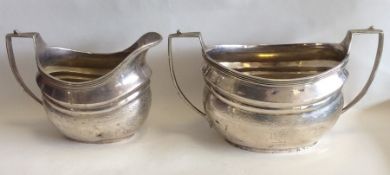 A pair of Georgian style oval silver cream and sug