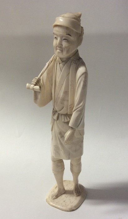 A carved ivory model of an Oriental man in standin