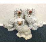 A pair of Staffordshire dogs together with one oth