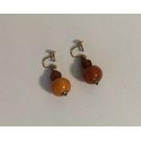 A pair of amber ear pendants with gold loop tops.