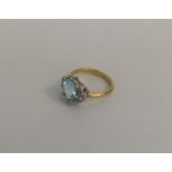 An aquamarine and diamond cluster ring in two colo
