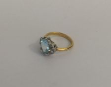 An aquamarine and diamond cluster ring in two colo