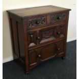 An oak chest of four drawers with panelled sides.