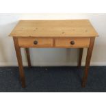 A pine two drawer side table on tapering supports.